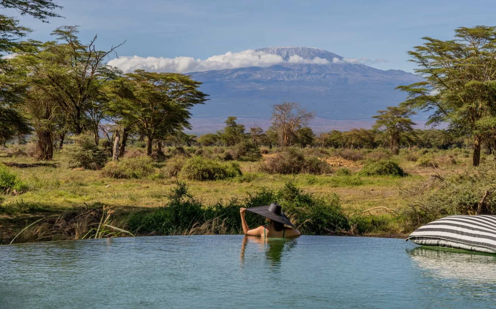 Luxury meets relaxation Female traveler enjoying a refreshing dip in the pool on an African safari getaway