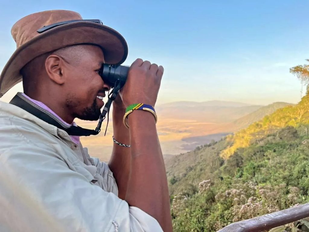 Experienced Tanzania safari guide surveying the Ngorongoro Crater floor from the rim — East Africa Safari Guides senior field guide