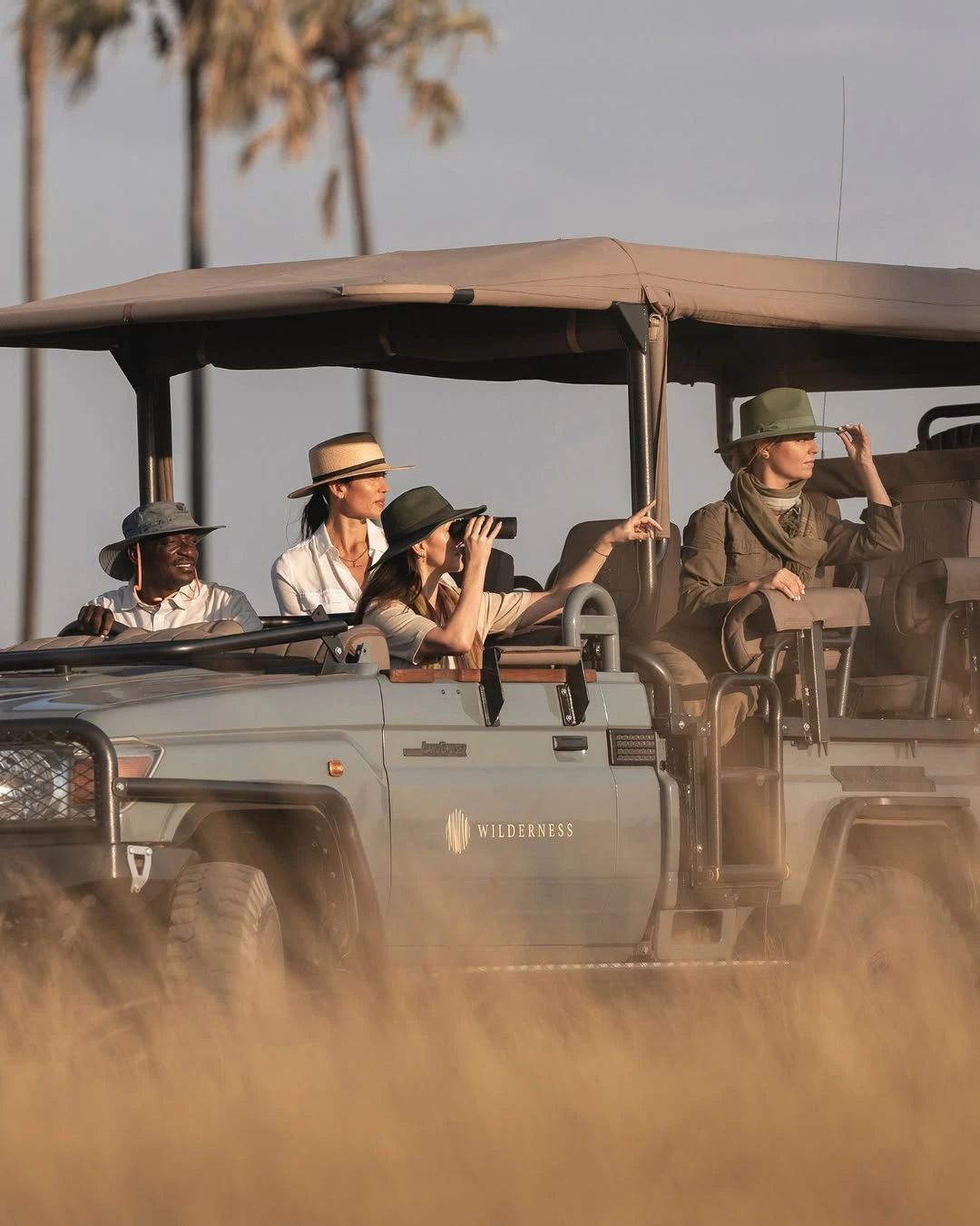 guests on African Safari open sided vehicle in Serengeti National Park